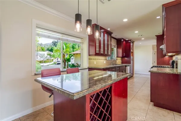 a kitchen with kitchen island granite countertop a sink and a refrigerator