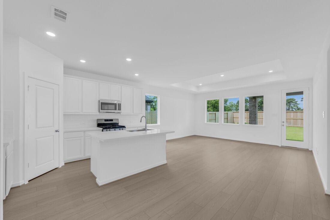 1107 Mattinson Rae Court Tomball, TX 77375 - Photo 3 of 32 a view of kitchen with stainless steel appliances refrigerator oven and white cabinets with wooden floor
