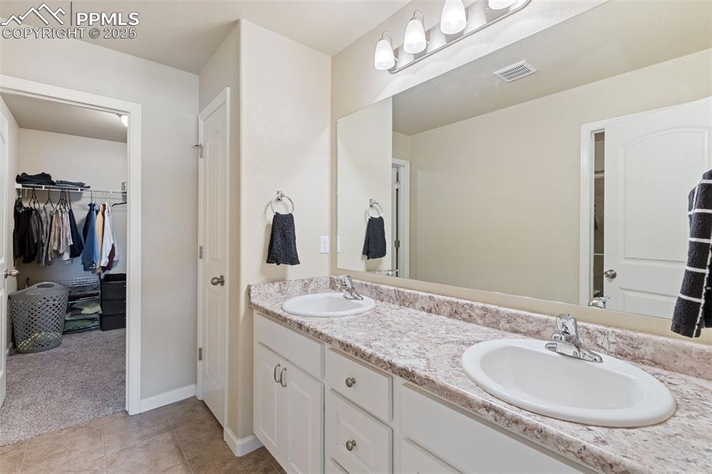 4139 Pk Hvn View Colorado Springs, CO 80917 - Photo 10 of 33 a bathroom with a granite countertop double vanity sink and a mirror