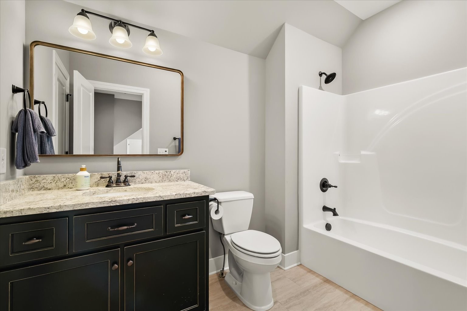1032 Abbey Rd Way Spring Hill, TN 37174 - Photo 46 of 68 a bathroom with a granite countertop sink toilet a large mirror a bathtub and shower