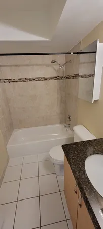 a bathroom with a granite countertop sink a toilet and bathtub