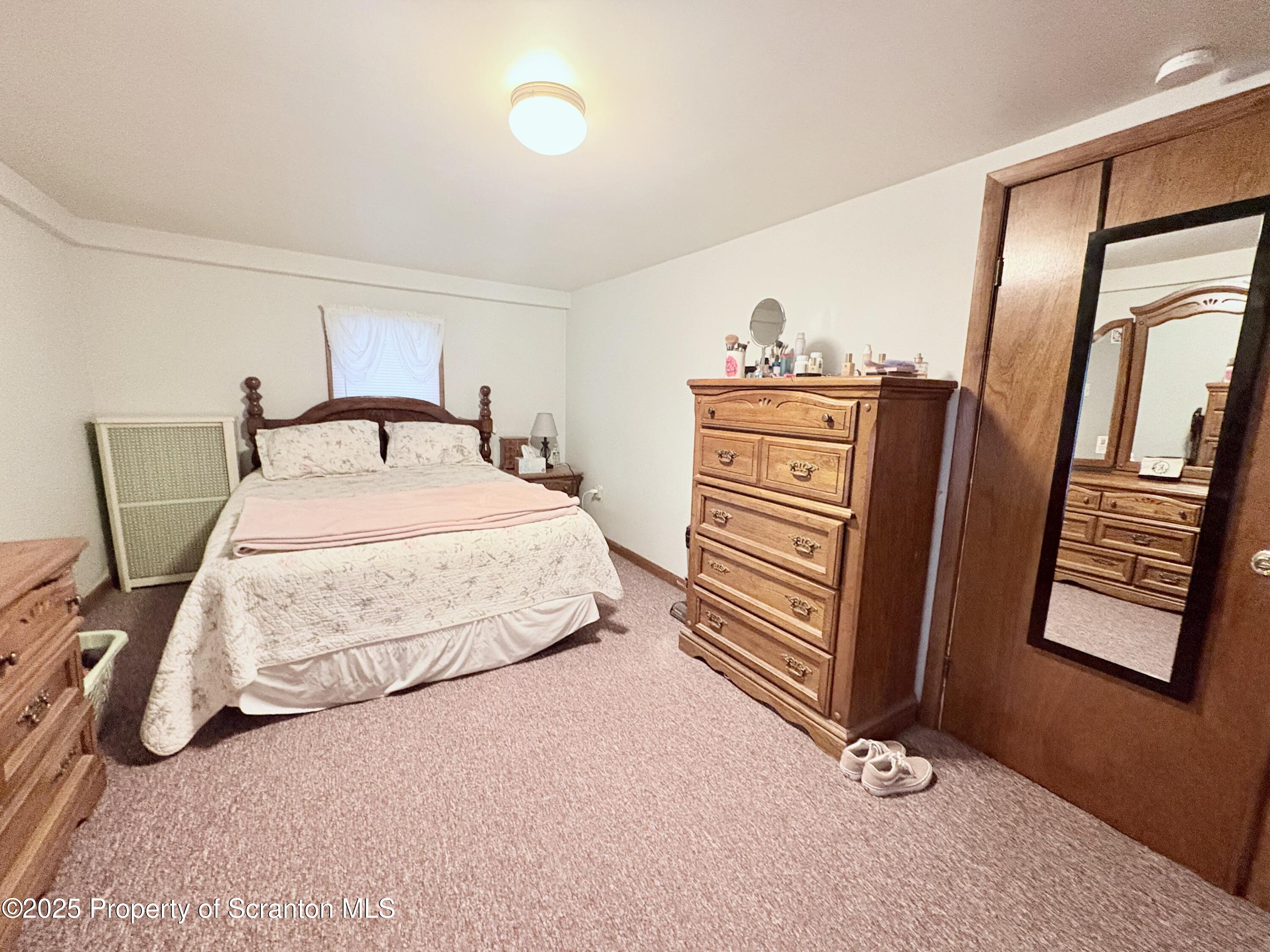 186 Cemetery Street Archbald, PA 18403 - Photo 17 of 28 a bedroom with a bed and dresser with mirror