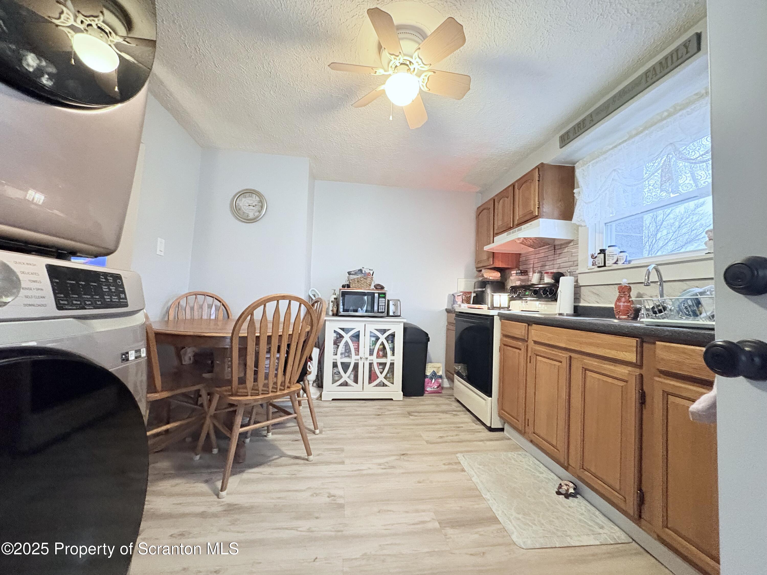 186 Cemetery Street Archbald, PA 18403 - Photo 10 of 28 a kitchen with stainless steel appliances granite countertop a stove top oven a sink a dining table and chairs with wooden floor