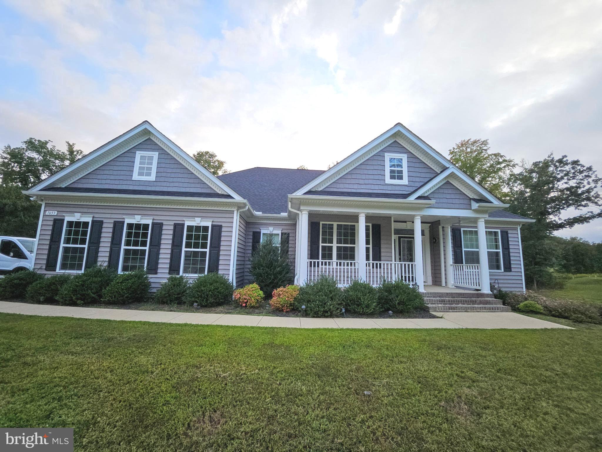 7653 Knotting Hill Lane Port Tobacco, MD 20677 - Photo 1 of 2 a front view of a house with a yard and potted plants