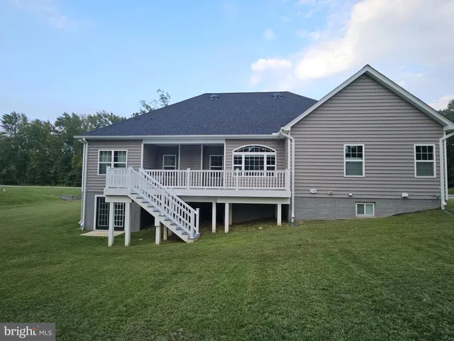 a view of a house with a yard and sitting area