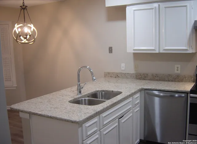 a view of a kitchen with a sink and a refrigerator