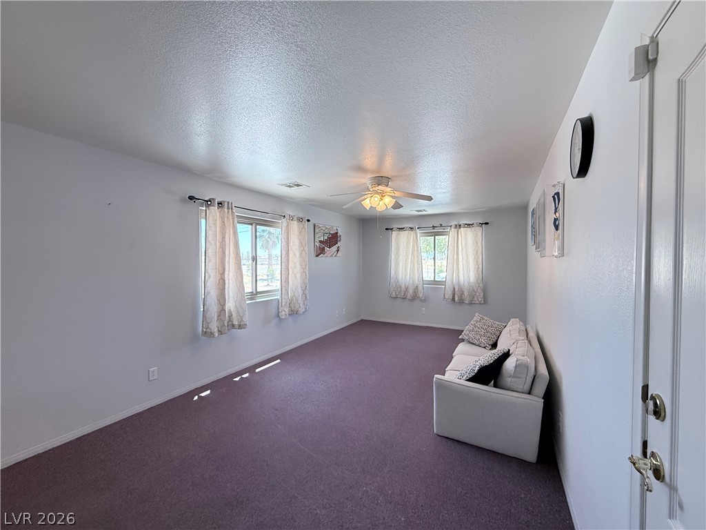 1220 East Gamebird Road Pahrump, NV 89048 - Photo 34 of 50 A versatile living area features plush carpeting and abundant natural light from multiple windows.