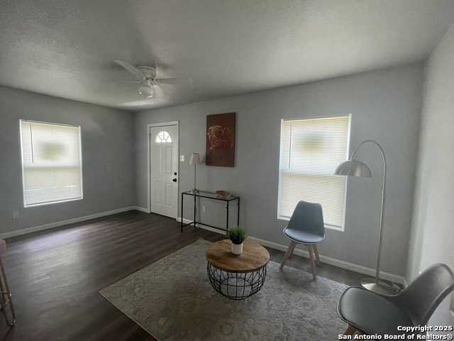 a living room with furniture a window and a potted plant