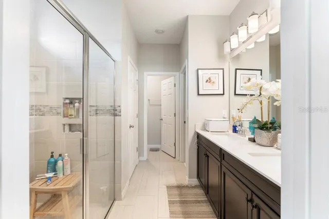 a en suite bathroom with a double vanity sink a mirror and a shower