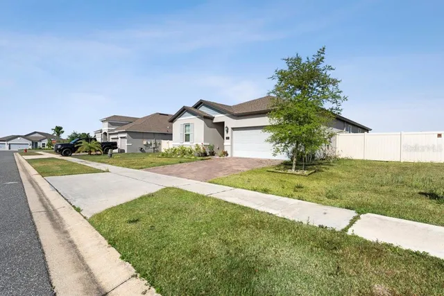 a view of a house with a big yard and large trees