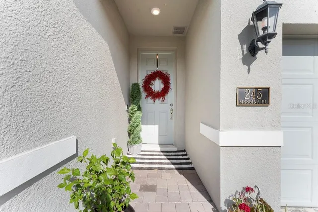 a hallway with flowers and a white door