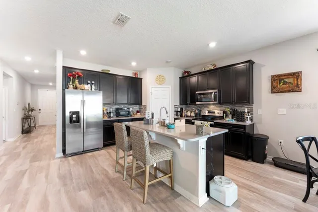 a dining room with furniture a chandelier and wooden floor