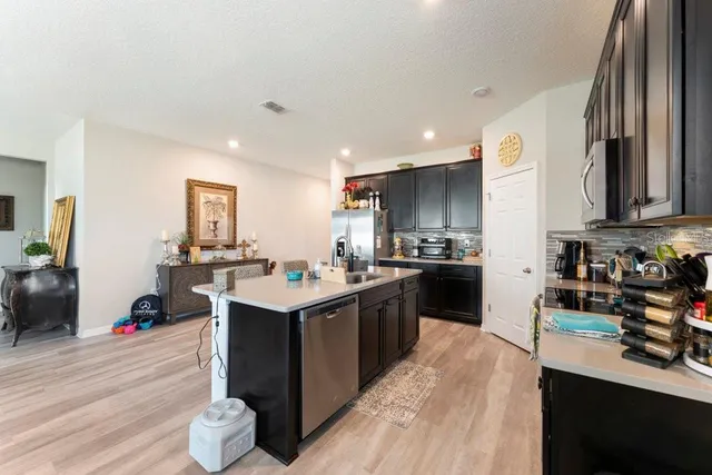 a kitchen with stainless steel appliances granite countertop a sink a stove and a refrigerator