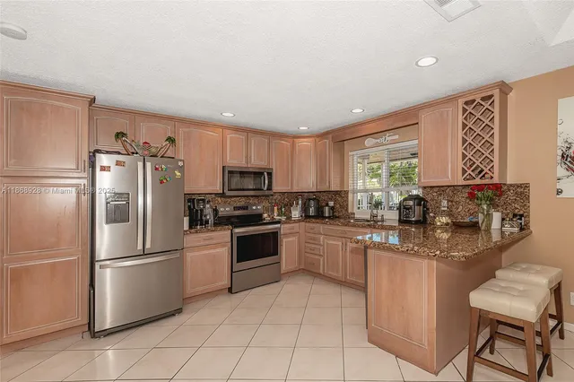 a kitchen with stainless steel appliances granite countertop a refrigerator sink and stove