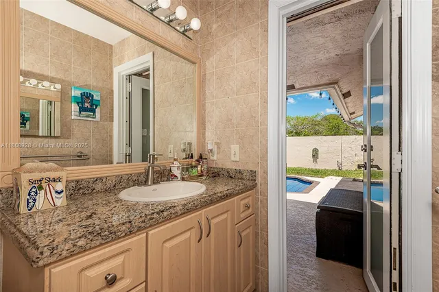 a bathroom with a granite countertop sink and a mirror