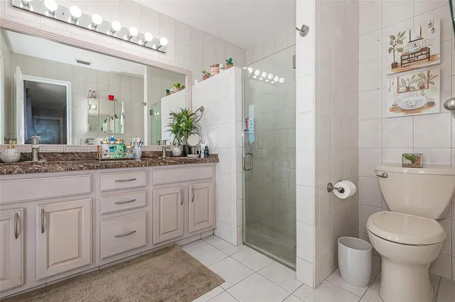 a bathroom with a granite countertop sink a toilet and shower