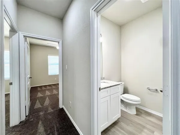 a bathroom with a granite countertop toilet and a sink