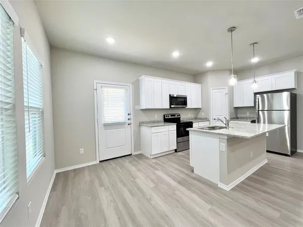 a kitchen with white cabinets and stainless steel appliances