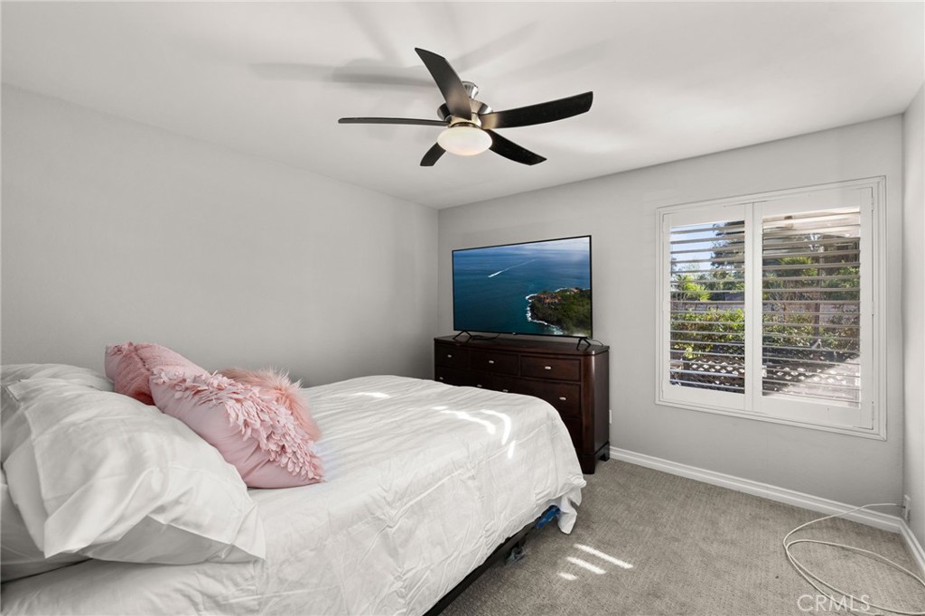 1274 Muirfield Road Riverside, CA 92506 - Photo 23 of 48 a bedroom with a bed a window and a flat screen tv