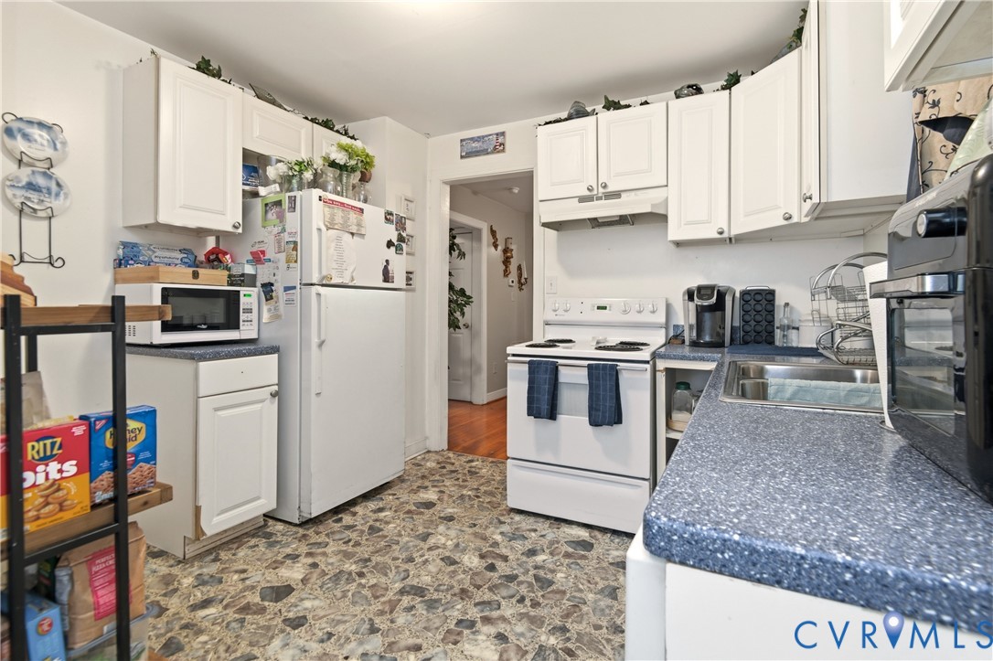 1311 Williamsburg Road Richmond, VA 23231 - Photo 17 of 32 a kitchen with stainless steel appliances granite countertop a refrigerator sink stove and white cabinets