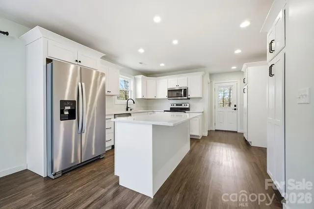 a kitchen with white cabinets and stainless steel appliances