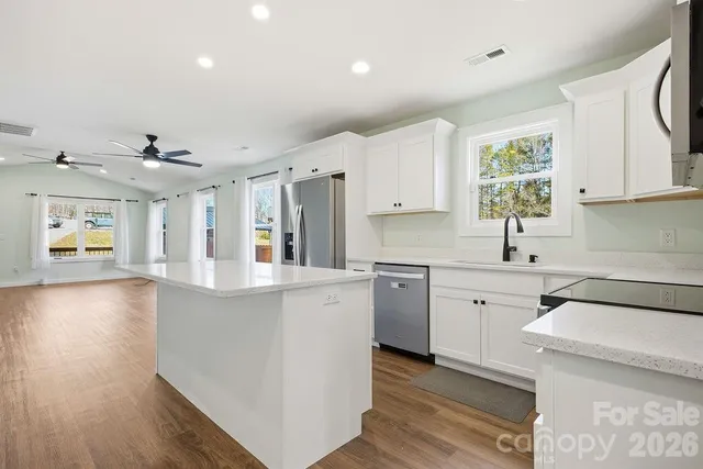 a kitchen with granite countertop a sink stove and cabinets
