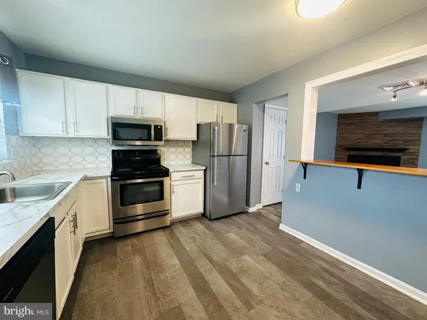 a kitchen with a refrigerator and a stove top oven