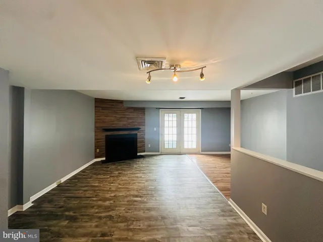 an empty room with windows and fireplace