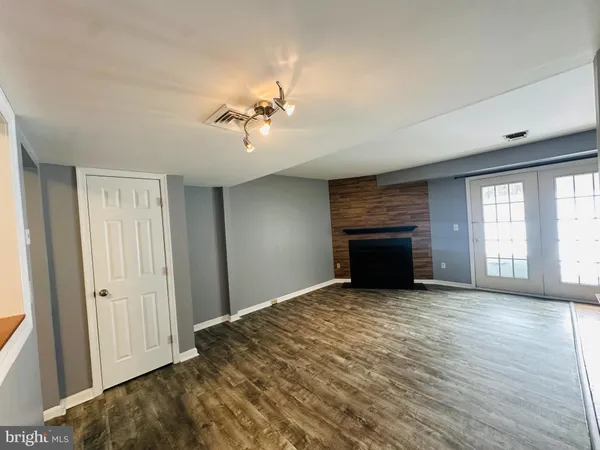 a view of empty room with a fireplace and wooden floor