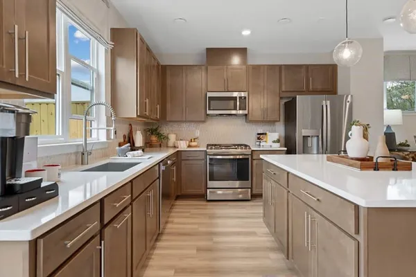 a kitchen with stainless steel appliances granite countertop a sink stove and cabinets