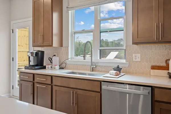 a large kitchen with stainless steel appliances kitchen island a large counter space a sink and appliances