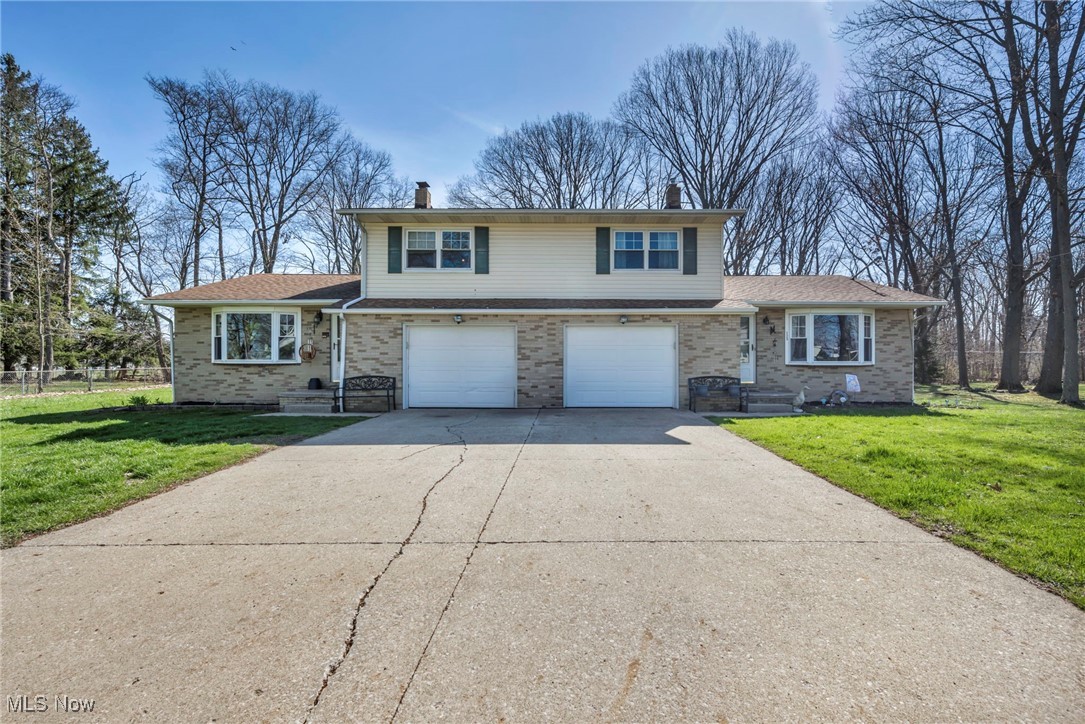 725 Neal Road, Unit 723 Akron, OH 44312 - Photo 1 of 47 Tri-level home featuring a chimney, driveway, a front yard, and a garage