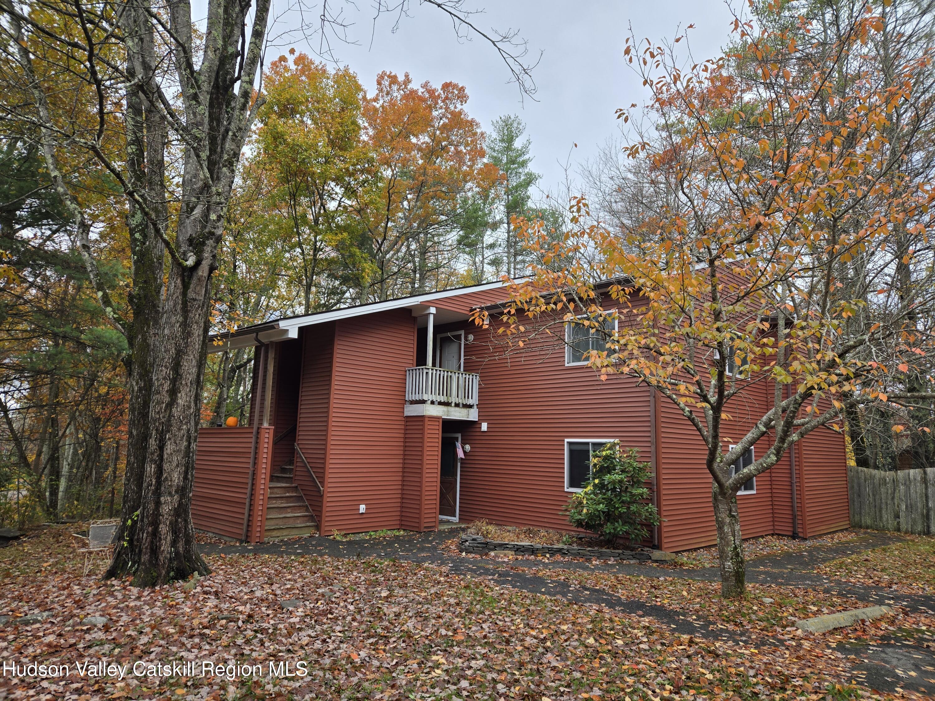 a view of a house with a large tree and wooden fence