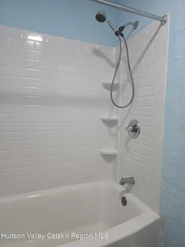 a bathroom with a bath tub with a shower