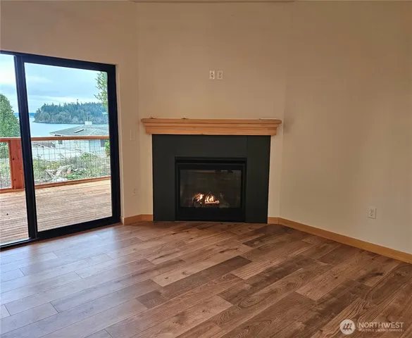 a view of empty room with wooden floor and fireplace