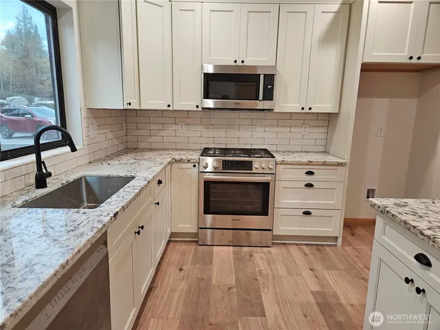 a kitchen with granite countertop a sink and a stove top oven