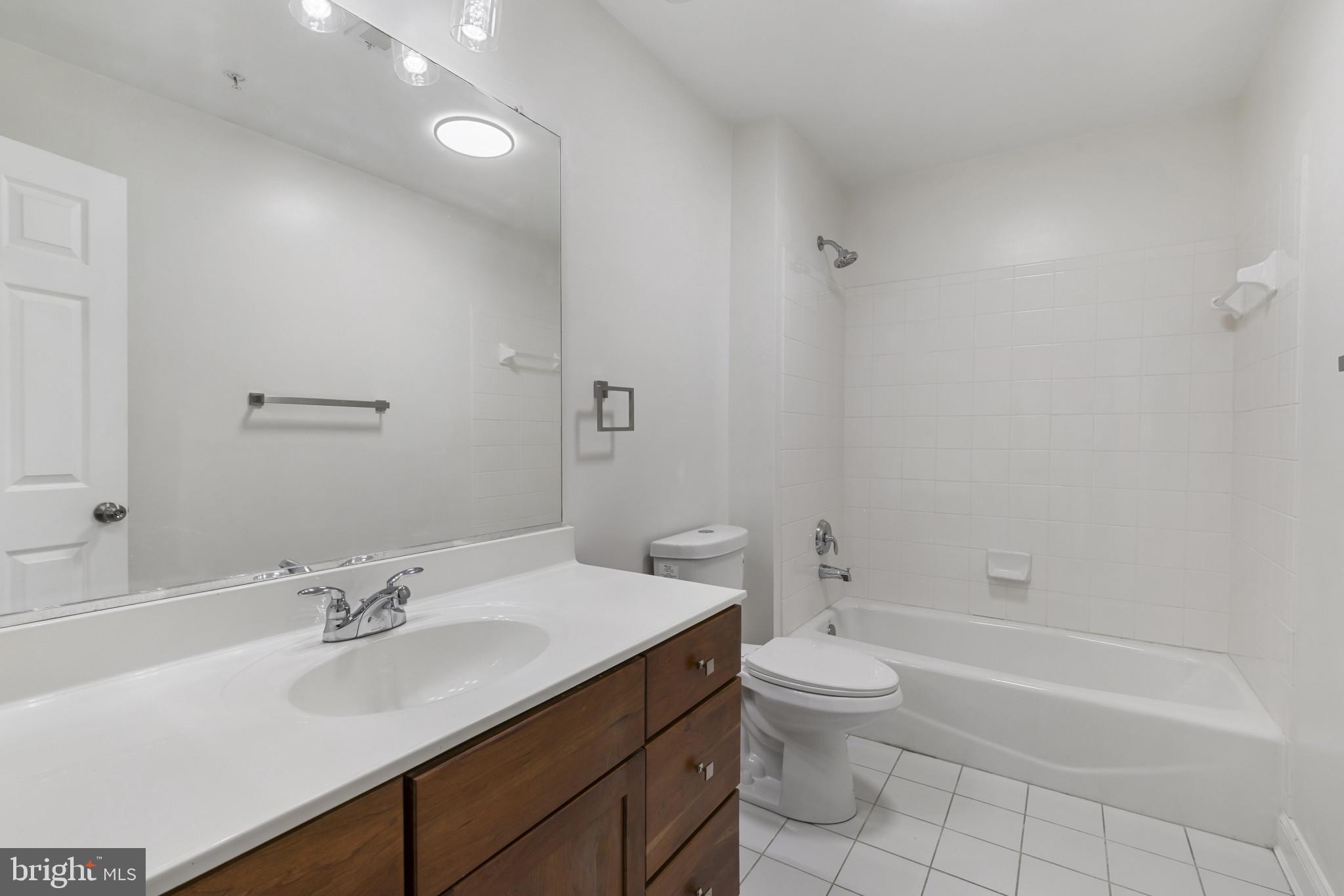 1256 Dockside Circle Baltimore, MD 21224 - Photo 11 of 41 a bathroom with a granite countertop sink a toilet and shower
