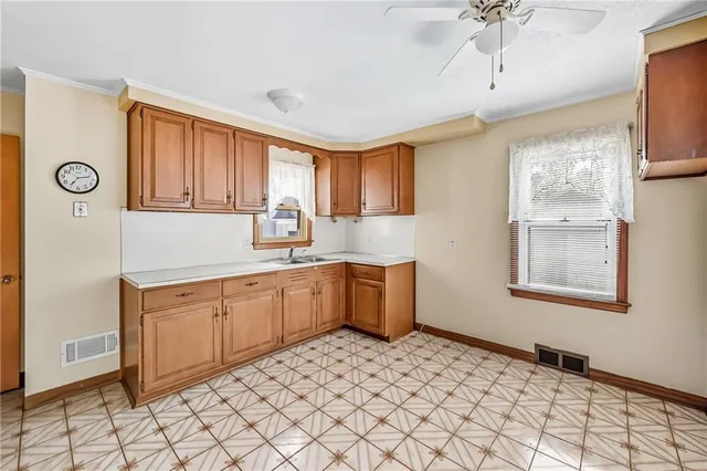 a kitchen with a sink window and cabinets