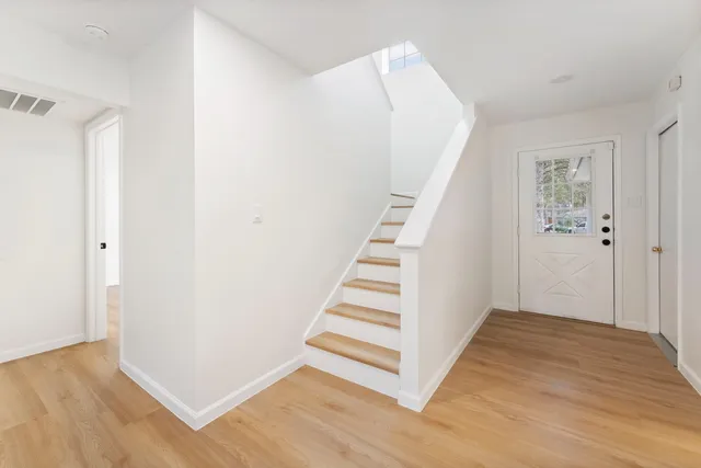 a view of a hallway with wooden floor and entryway