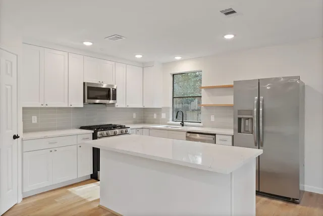 a kitchen with stainless steel appliances a refrigerator sink and microwave