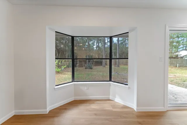 an empty room with wooden floor and a window