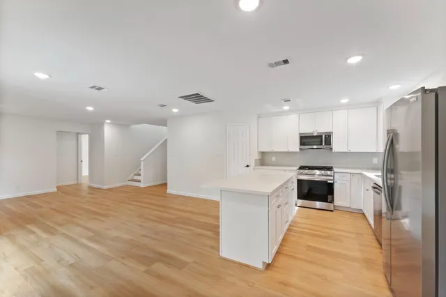 a large kitchen with kitchen island a sink stainless steel appliances and cabinets