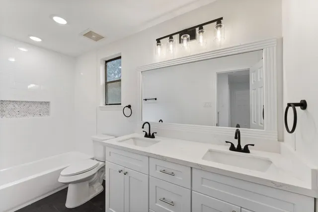 a bathroom with a sink a toilet and a mirror