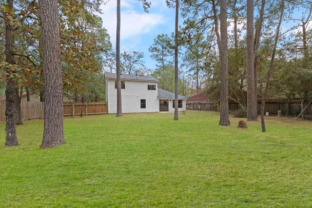 a view of a house with backyard and a tree