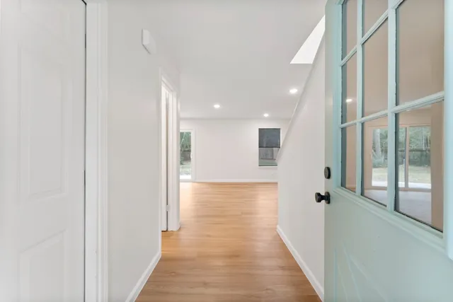 a view of a hallway with wooden floor and staircase