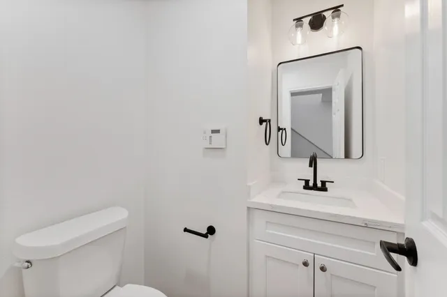 a bathroom with a toilet sink and mirror