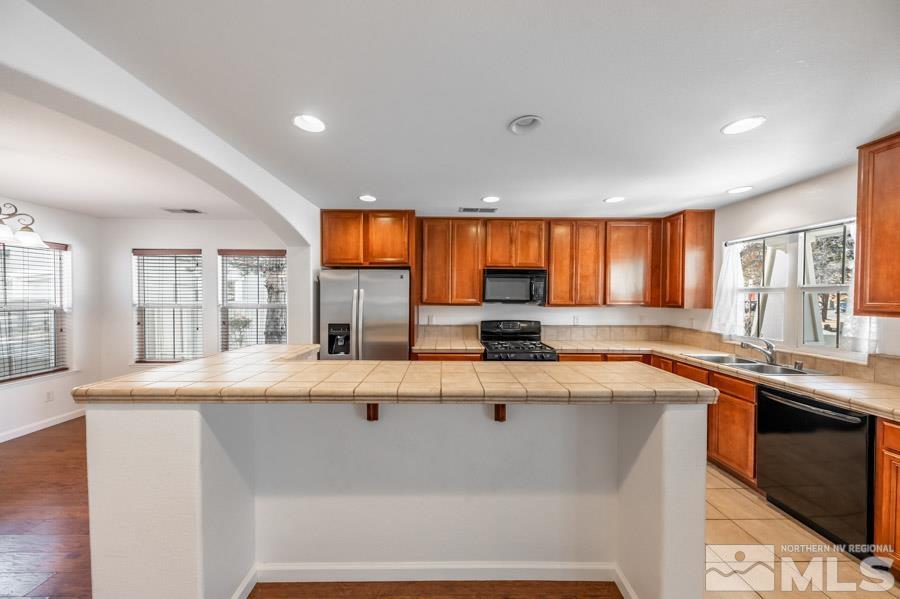 1680 Spicewood Circle Reno, NV 89523 - Photo 11 of 39 a kitchen with stainless steel appliances granite countertop a sink a stove and a refrigerator