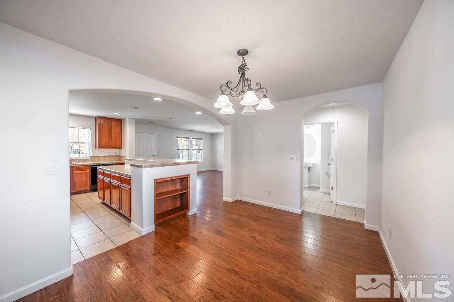 1680 Spicewood Circle Reno, NV 89523 - Photo 18 of 39 a living room with kitchen island a chandelier and wooden floors