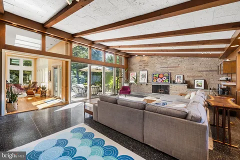 a living room with furniture a rug and a large window