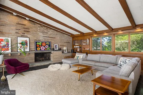 a living room filled with furniture and floor to ceiling windows